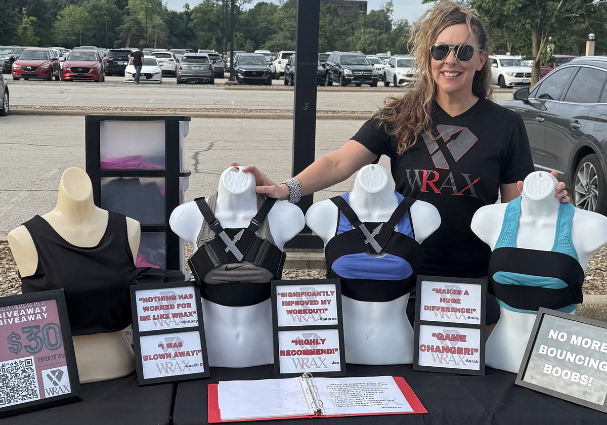 Frankie at the WRAX booth with harnesses shown on four display forms and framed customer quotes