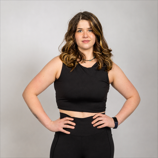 Woman wearing the WRAX Apex high-impact sports bra with patented bounce control technology designed to reduce upward and lateral breast movement during running, HIIT, and combat sports.