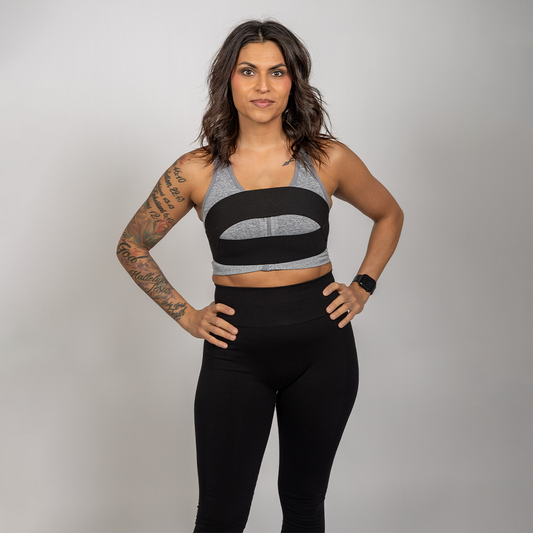Woman wearing the WRAX Rebel patented bounce control harness over a sports bra to reduce breast movement during running and high-impact exercise.